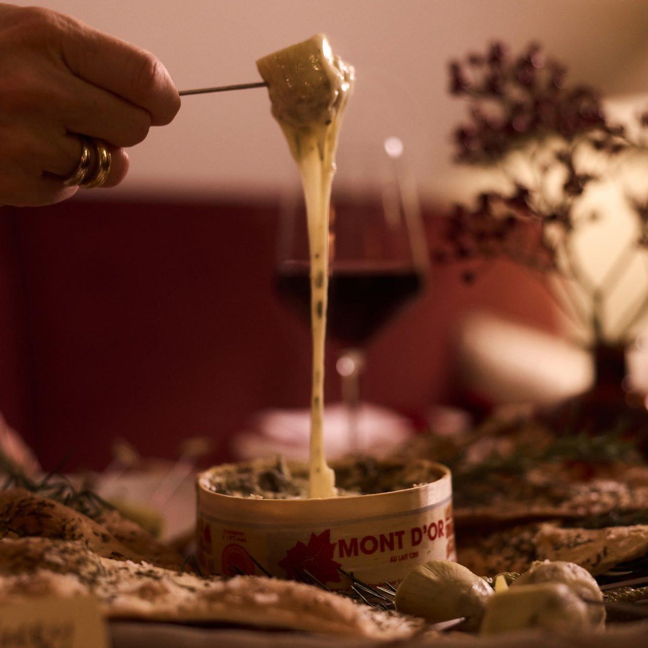 a table with a cake, wine, candles and a wreath