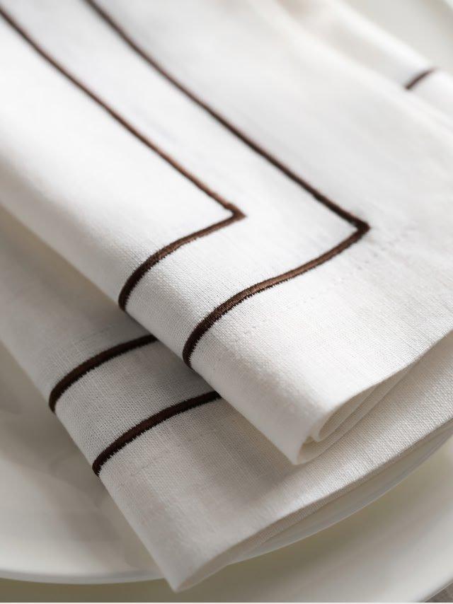 a stack of white plates with brown stripes on them