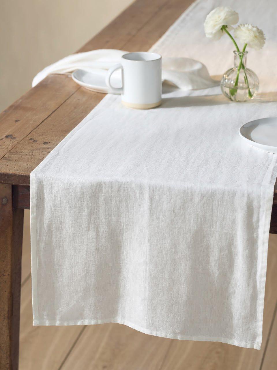 a table with a white tablecloth and a white vase