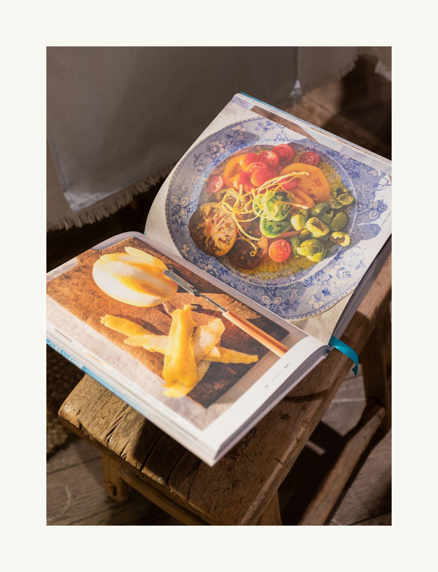 a book open to a picture of food on a wooden table