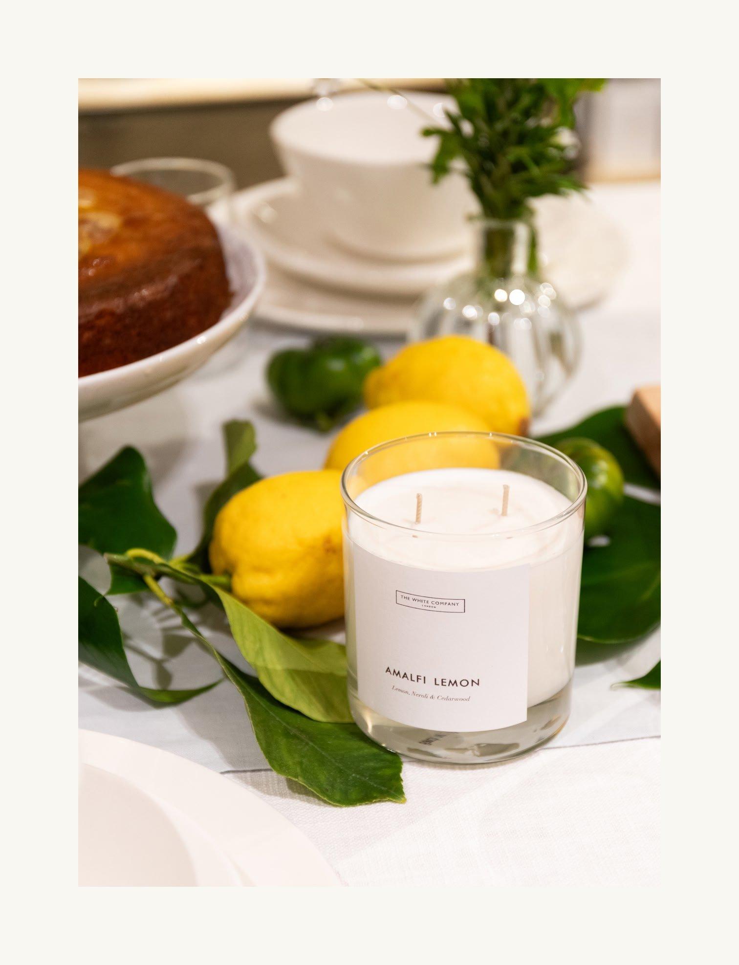 a candle and lemons on a table with a cake