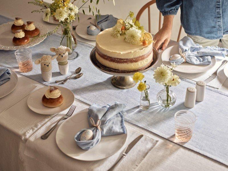 a table with a cake and flowers on it and a plate of food