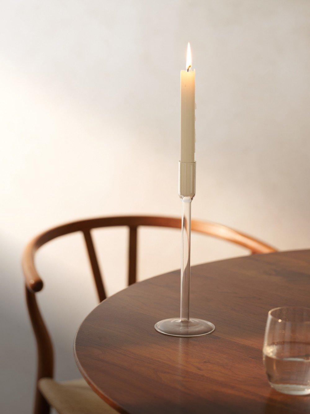 a candle on a table next to a glass of water