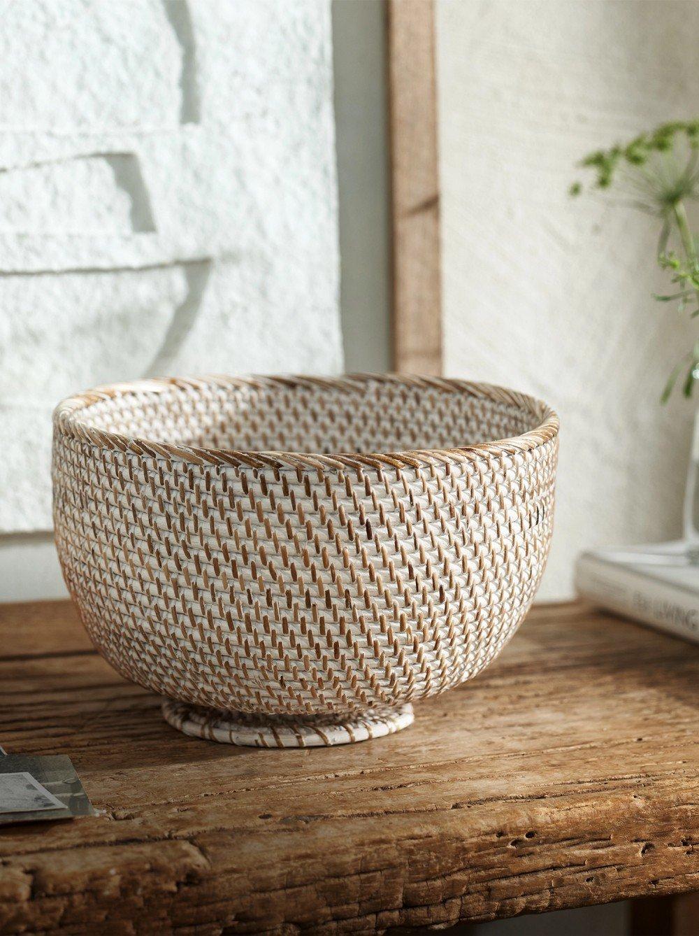 a white and brown woven bowl sitting on a wooden table