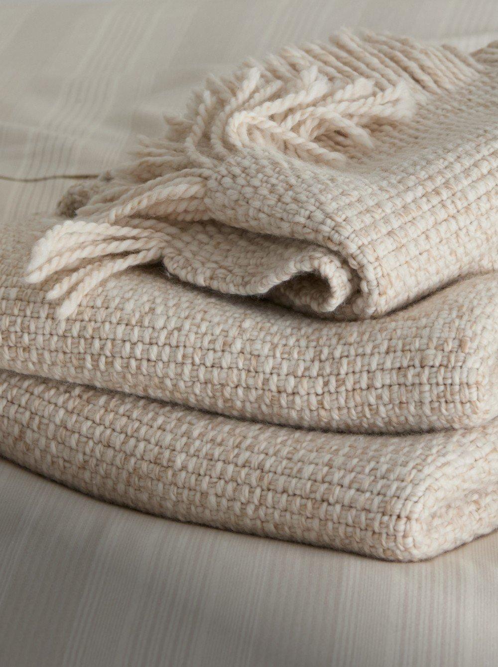 a stack of towels on a bed with a white sheet