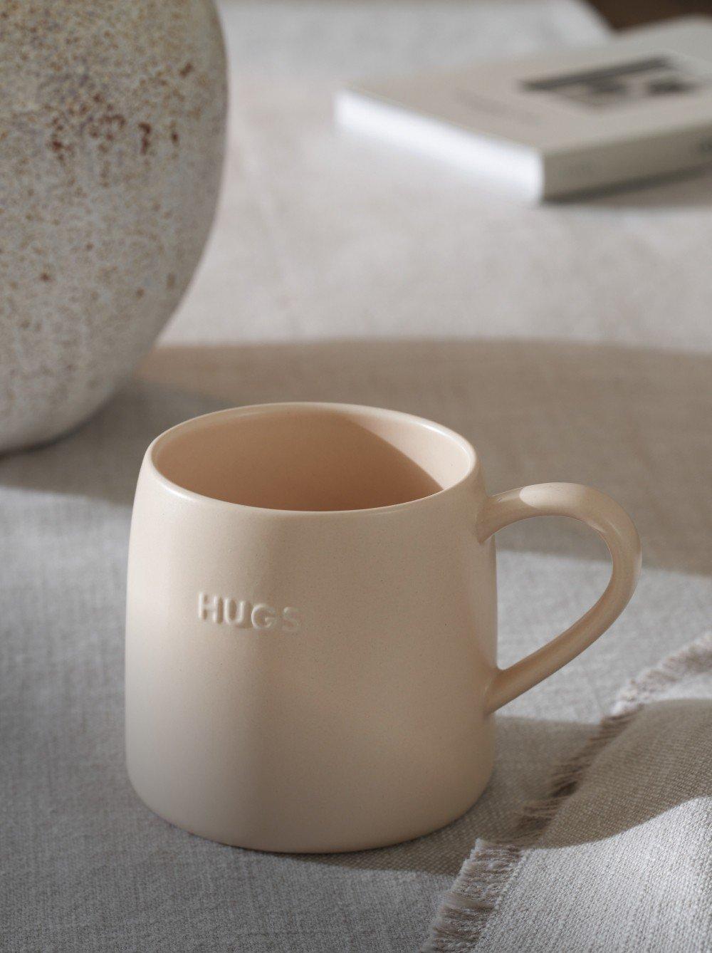 a mug with a word on it sitting on a table