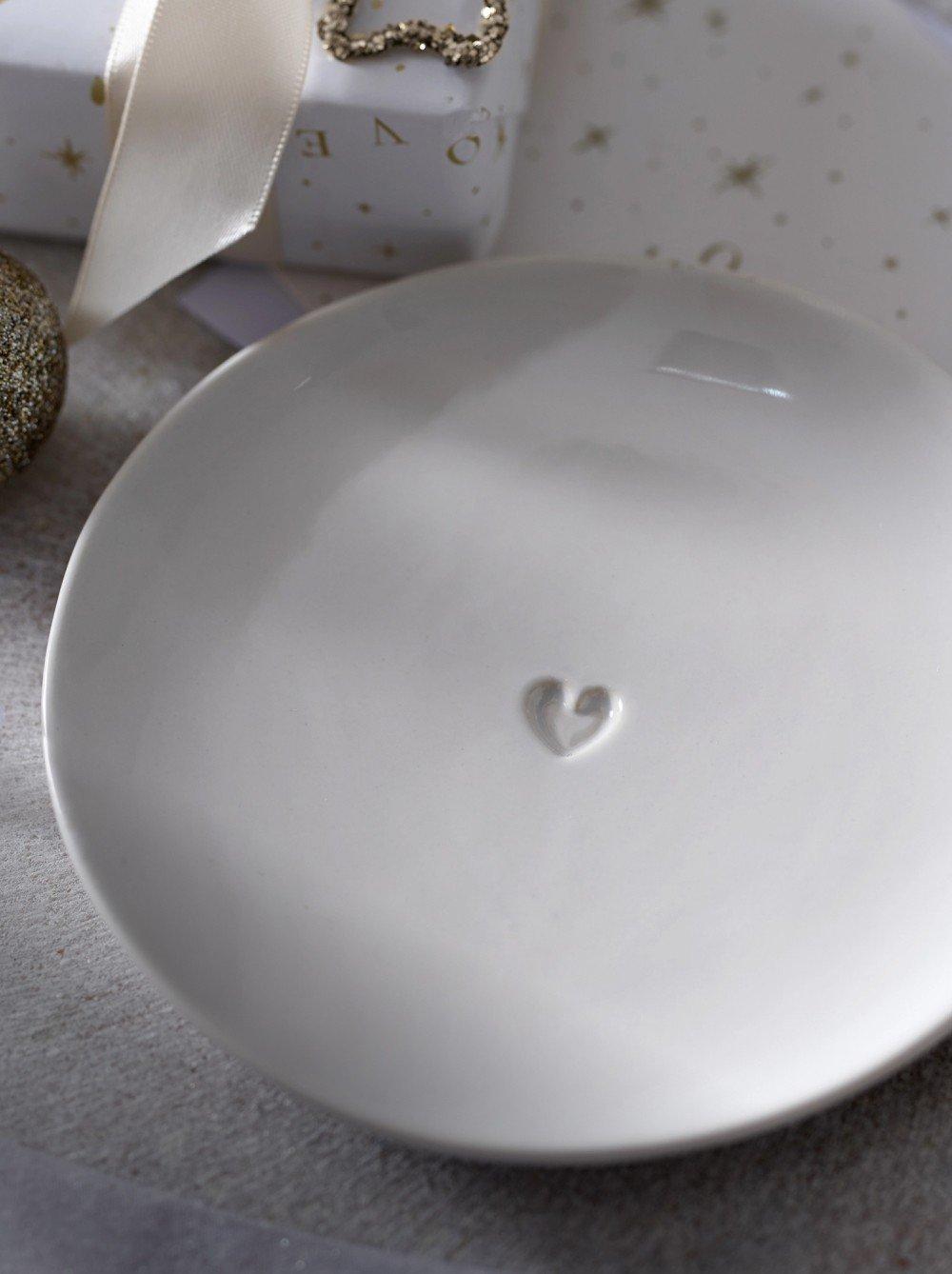 a white plate with a heart shaped design on it sitting on a table