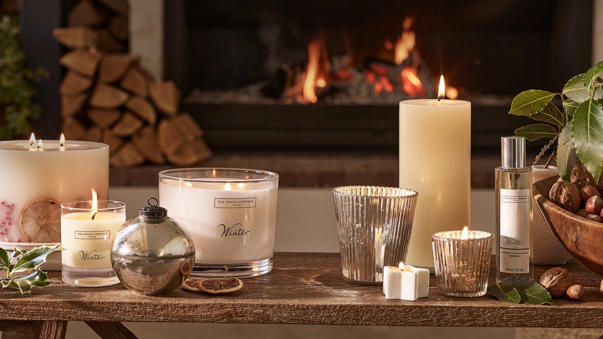 a table with candles and other items in front of a fireplace