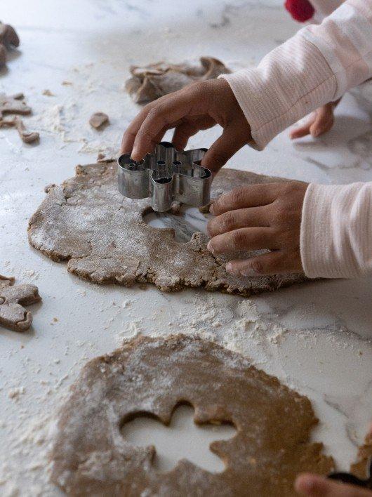 a person cutting cookies with cookie cutters on a table