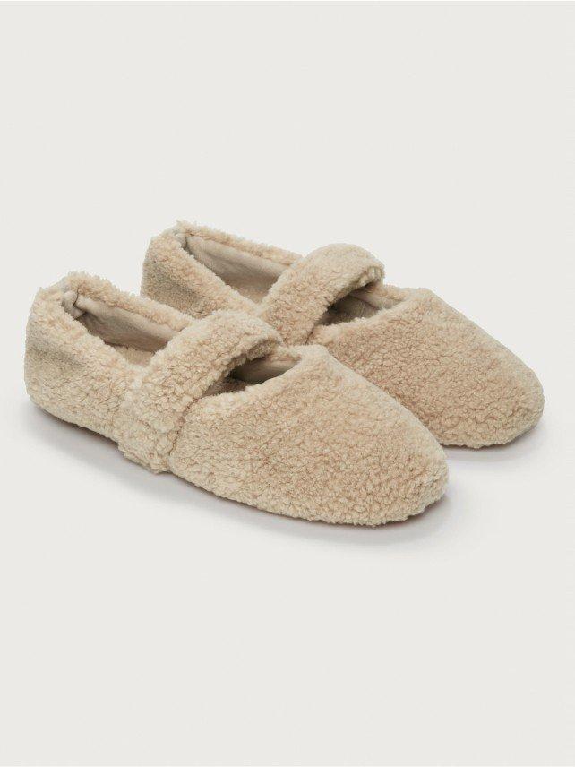 a pair of beige slippers with a double strap