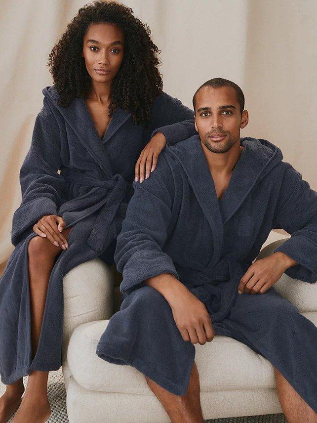 a man and woman in a bathrobe sitting on a couch