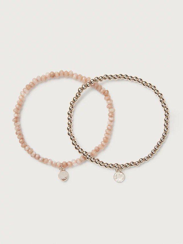 two bracelets with pink beads and a gold disc