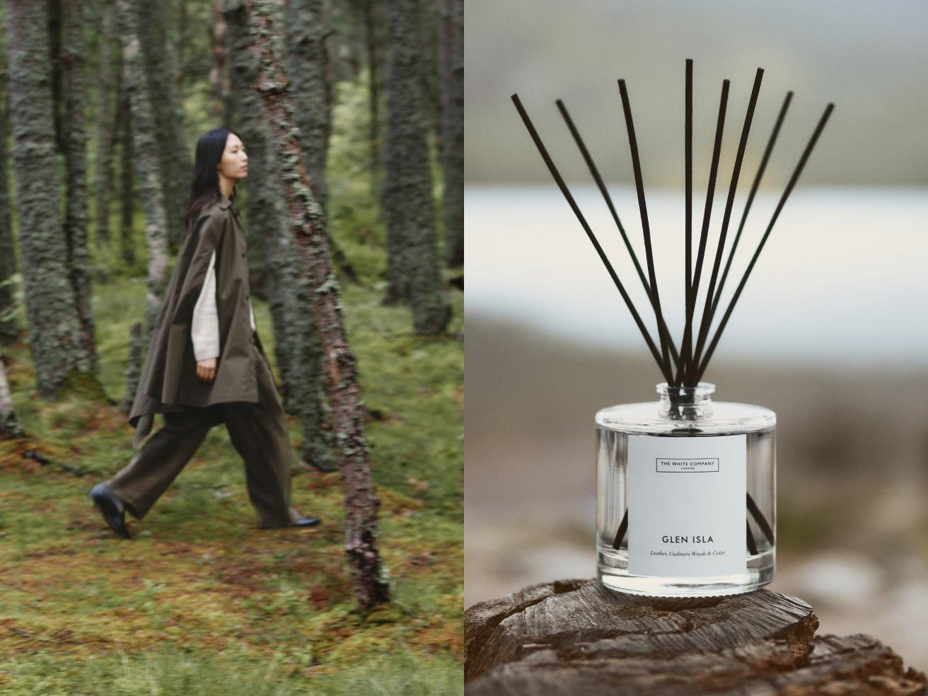 a woman walking through the woods with a reed diffuser in her hand
