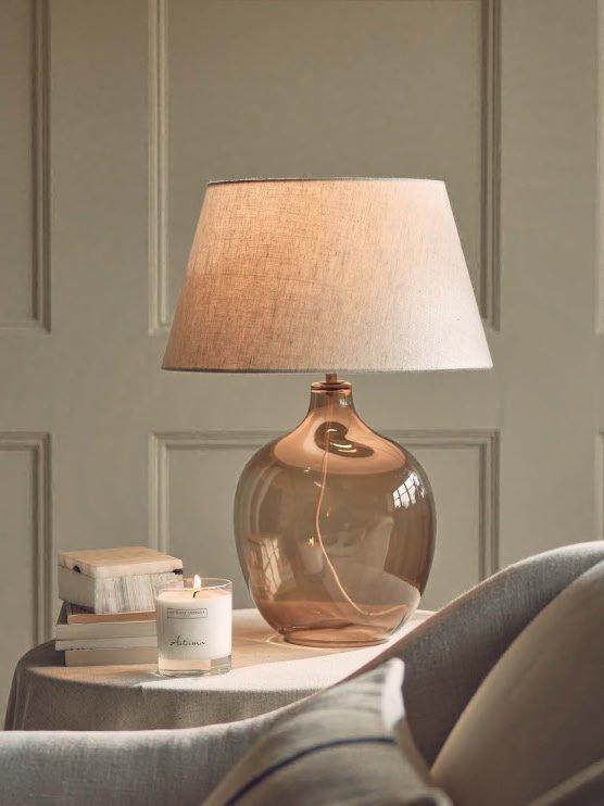 a table with a lamp on it and a book on it