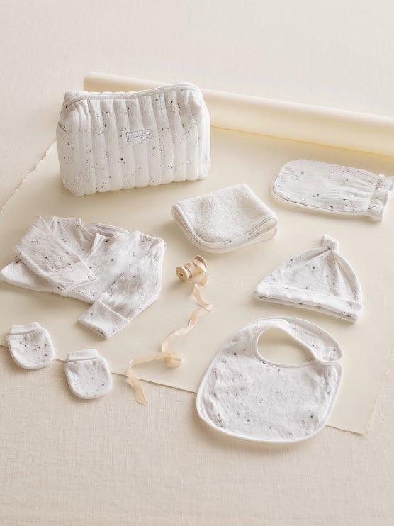 a white baby set with a bib, bib holder, and a bib