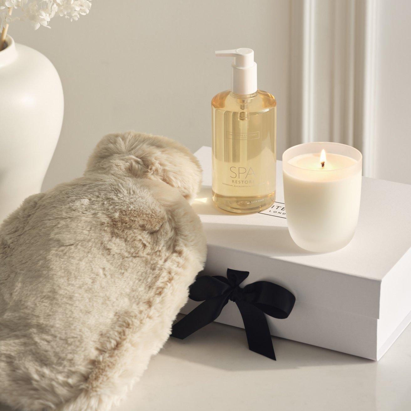 a candle, hot water bottle, and a candle holder on a table