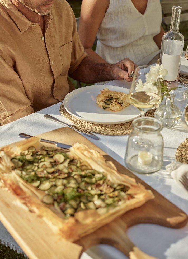 a man and woman sitting at a table with food on it