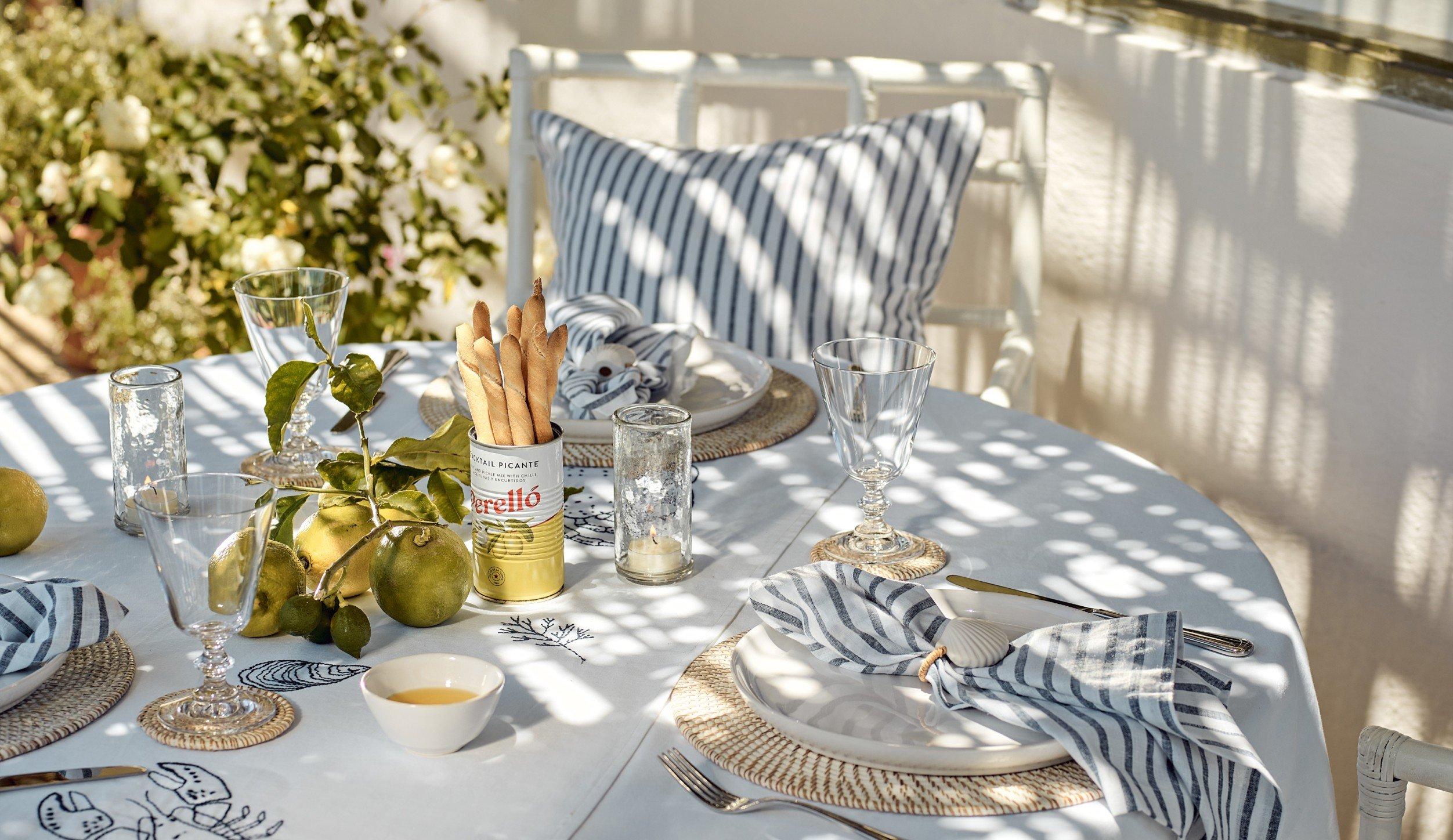 a table set with plates, napkins, and silverware on a patio