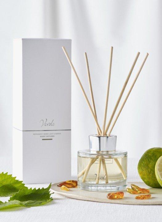 a bottle of reed diffuser with lime and leaves