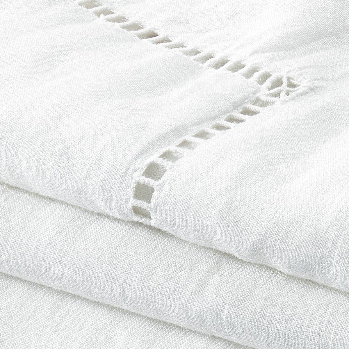 a stack of white sheets with holes in them