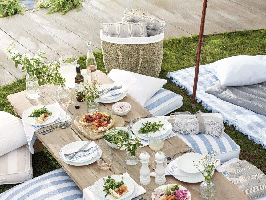 a table with a bunch of food on it in the grass