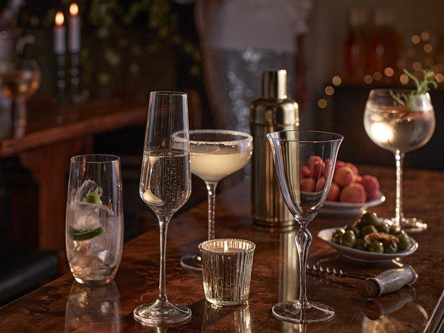 a bar with glasses, wine and other drinks on a table