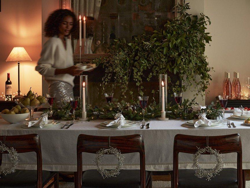 a woman standing in front of a table with a candle on it