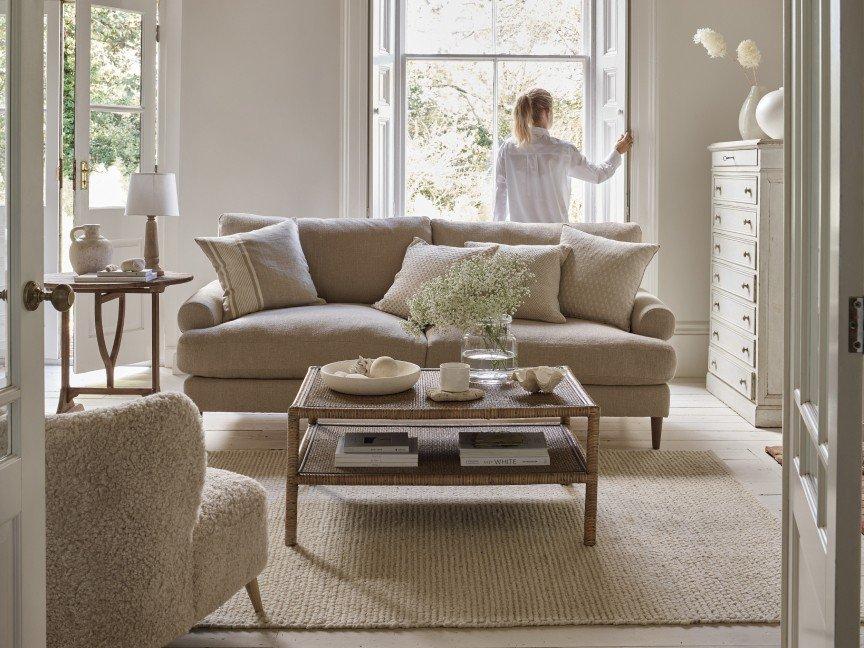 a woman standing in a living room looking out a window