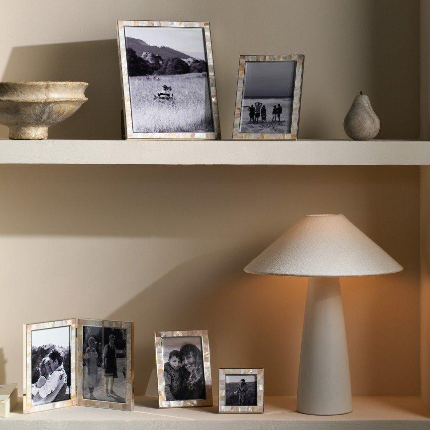 a shelf with a lamp, a picture frame and a lamp shade