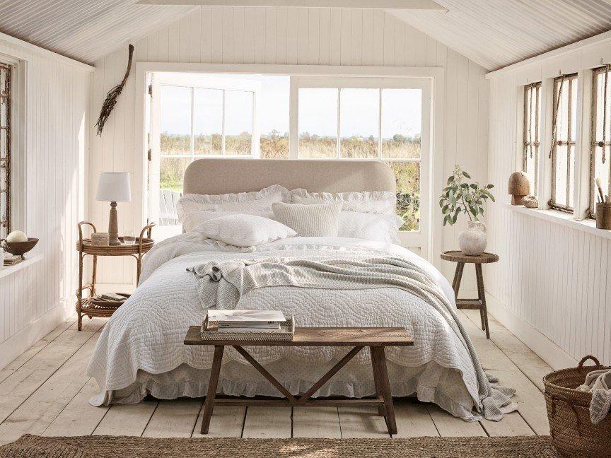 a bedroom with a bed, a table and a window