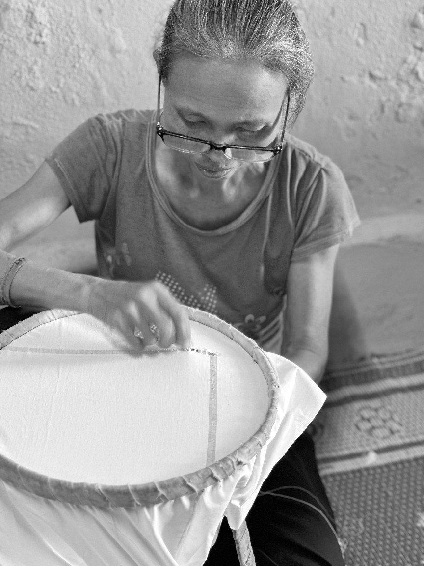 a woman sitting on the floor with a piece of fabric