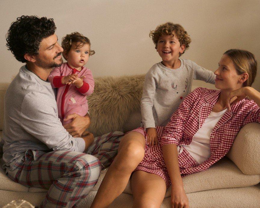 a man and woman sitting on a couch with two children