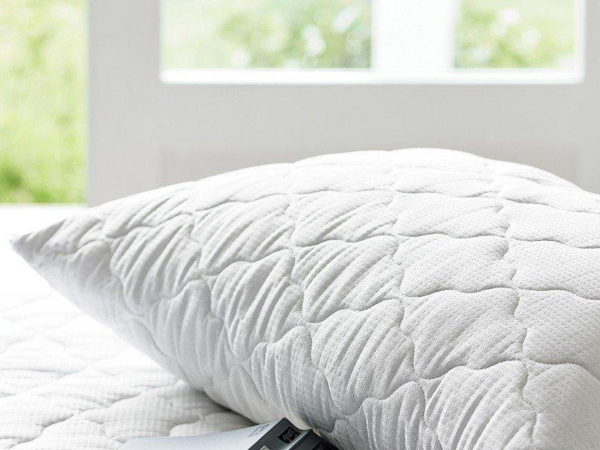 a pillow with a remote control sitting on top of it
