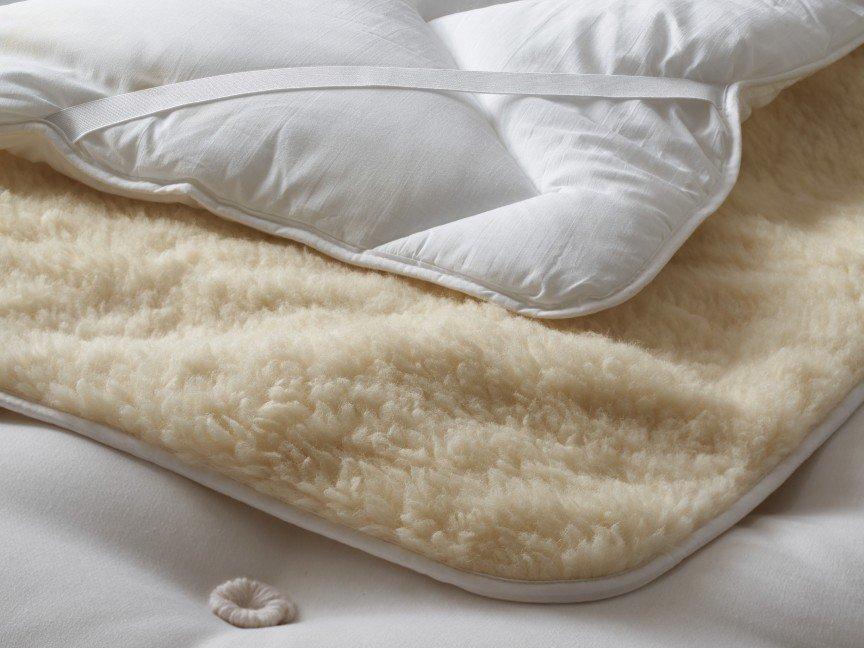 a close up of a mattress with a white blanket on top