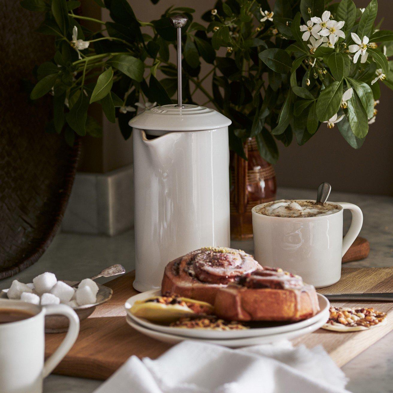 a table with a plate of pastries and coffee on it