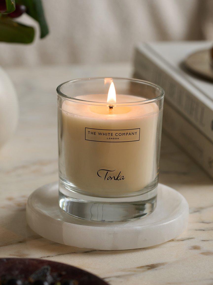a candle sitting on a marble table next to a book