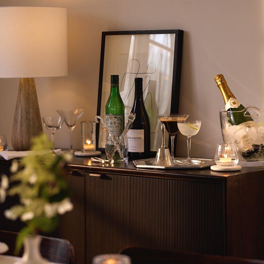 a table with wine bottles and glasses on it with a picture