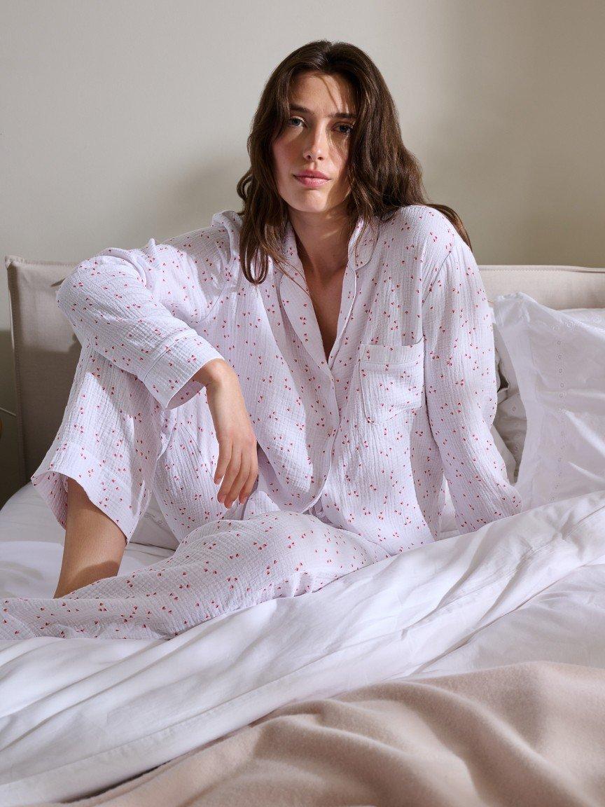 a woman laying in bed with breakfast and a glass of orange juice