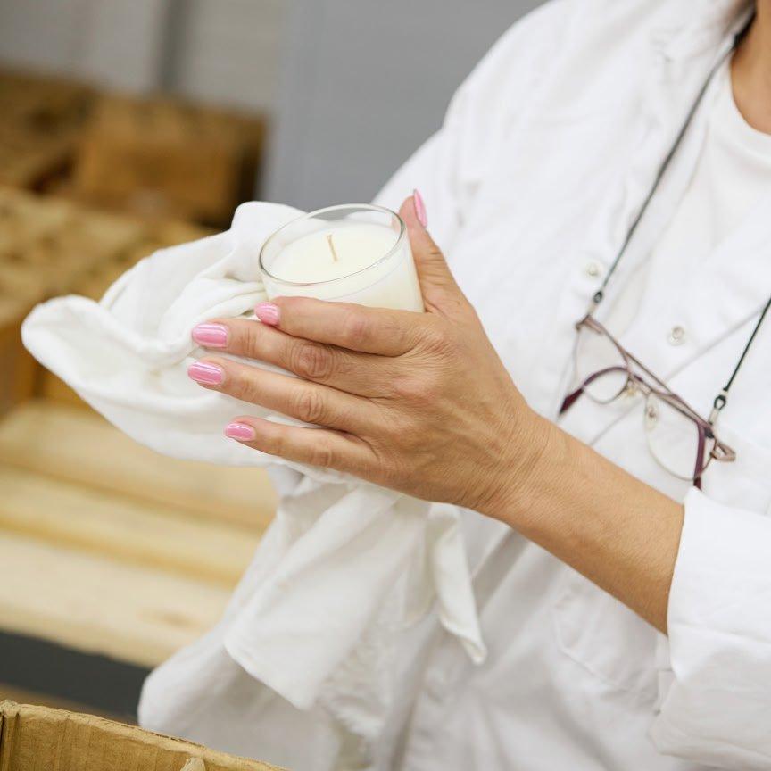 a woman in white lab coat holding a glass of something