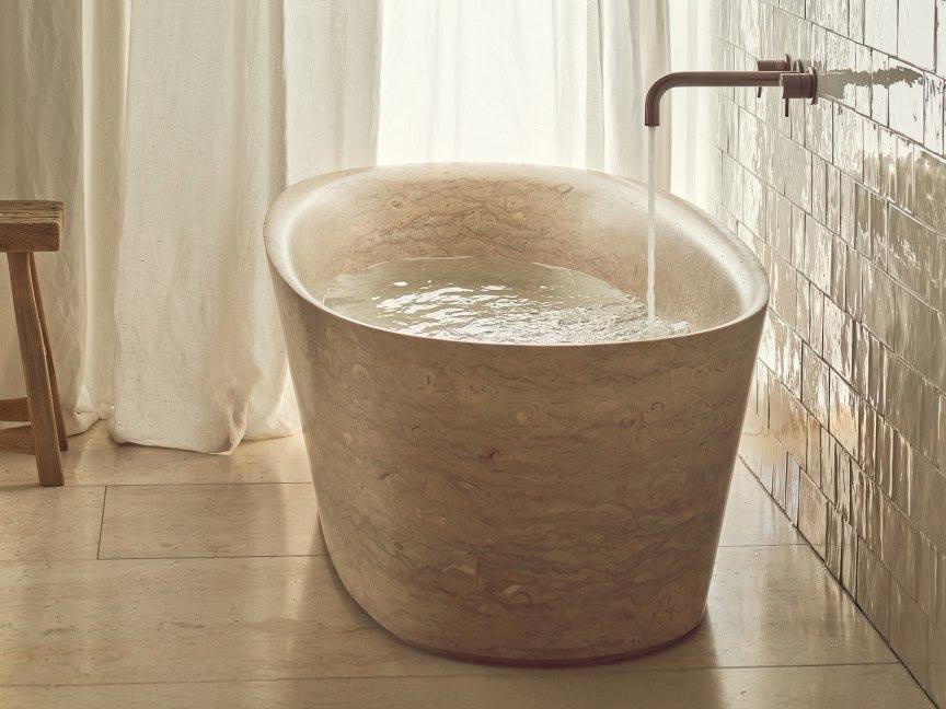a large stone bathtub sitting in a bathroom next to a shower