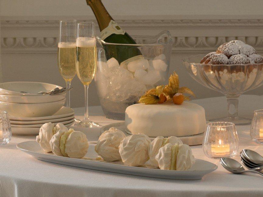 a table with a cake, wine, and candles on it