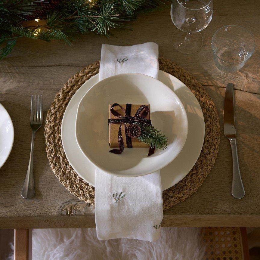 a plate with a gift wrapped in a napkin on a table