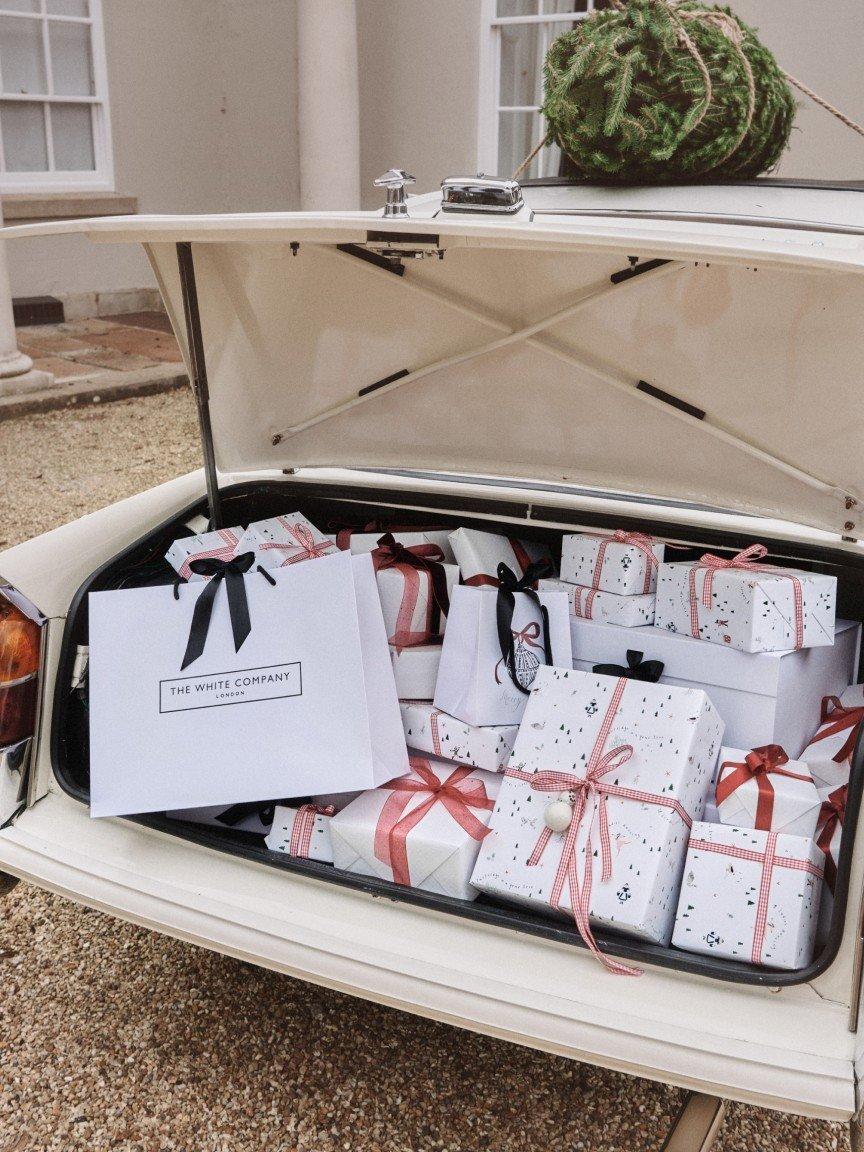 a trunk full of wrapped presents in the back of a car