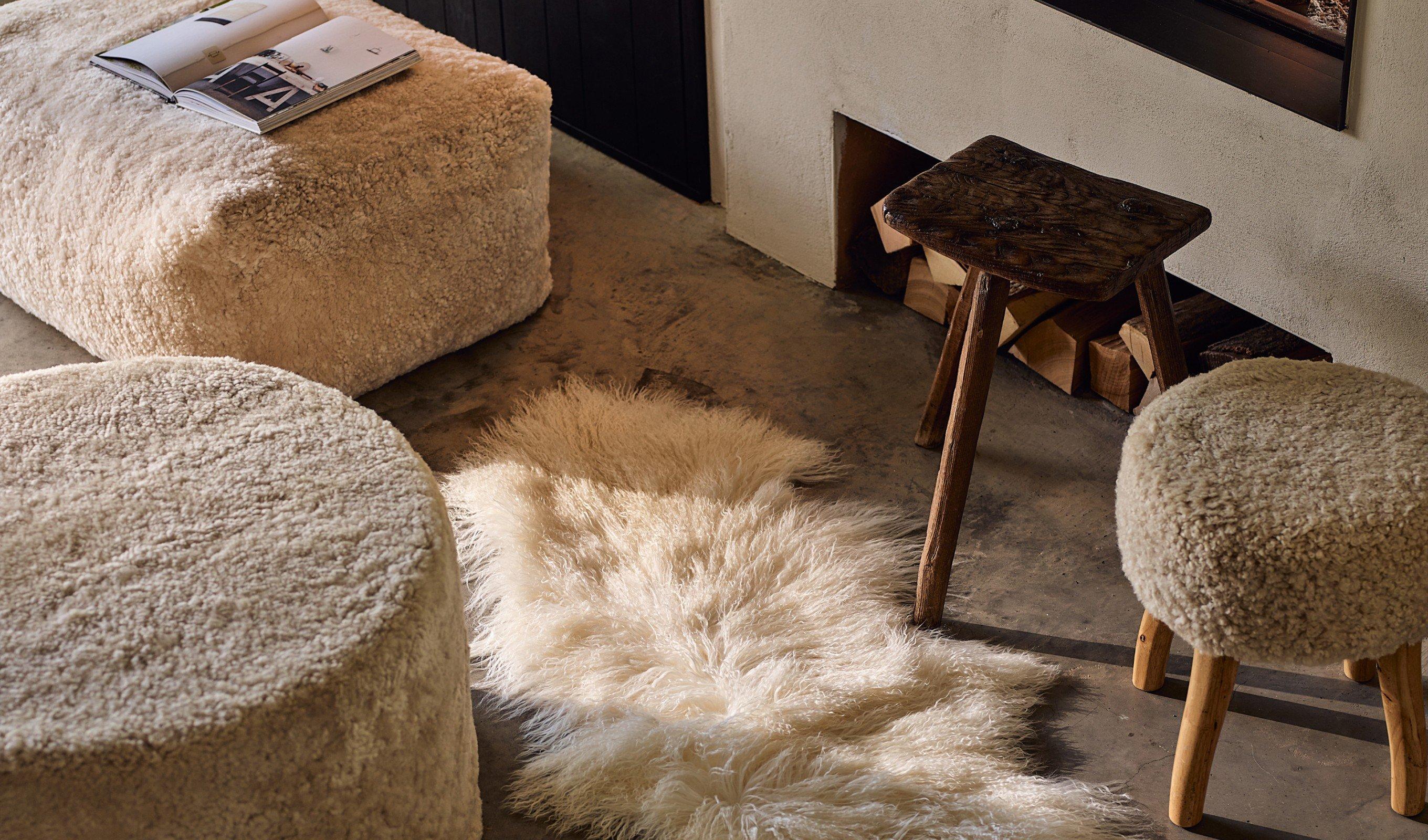 a living room with a fireplace and a couch and ottoman