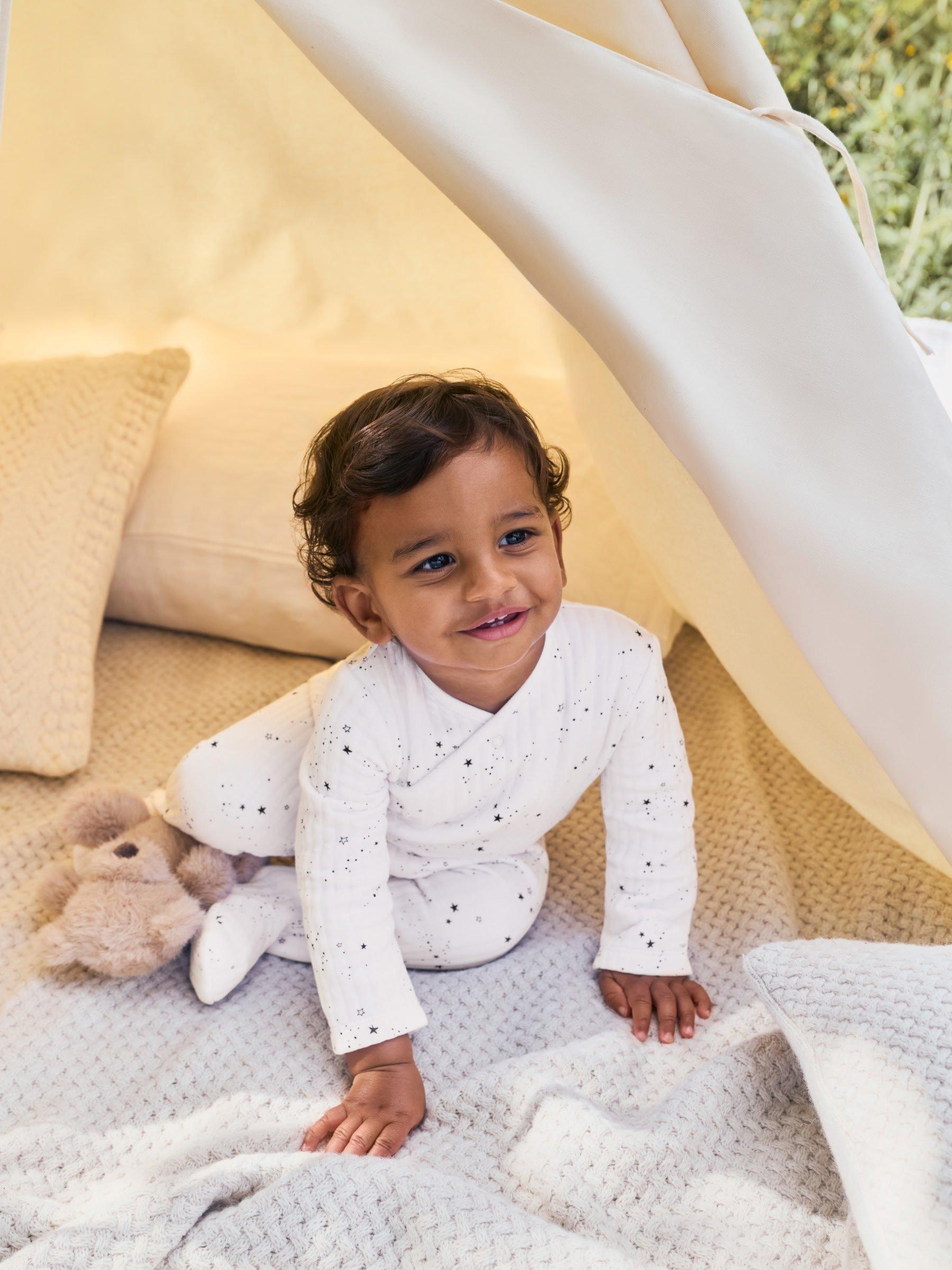 baby in a babygrow in a tent 