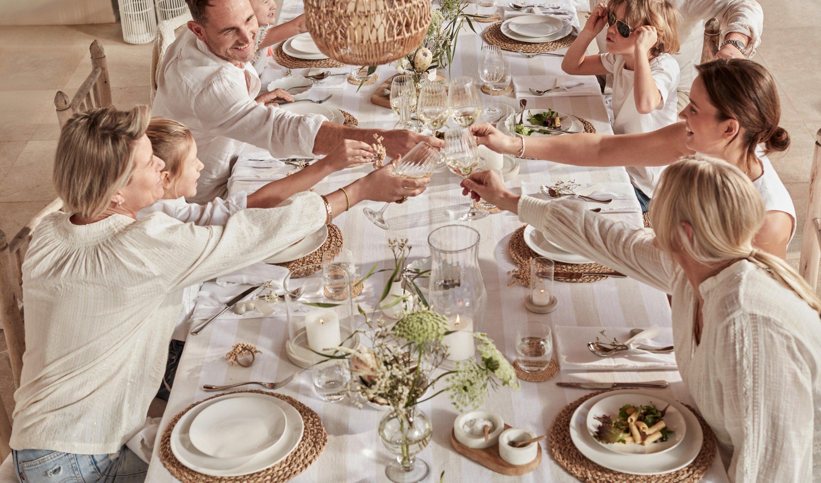 a group of people sitting at a table toasting each other