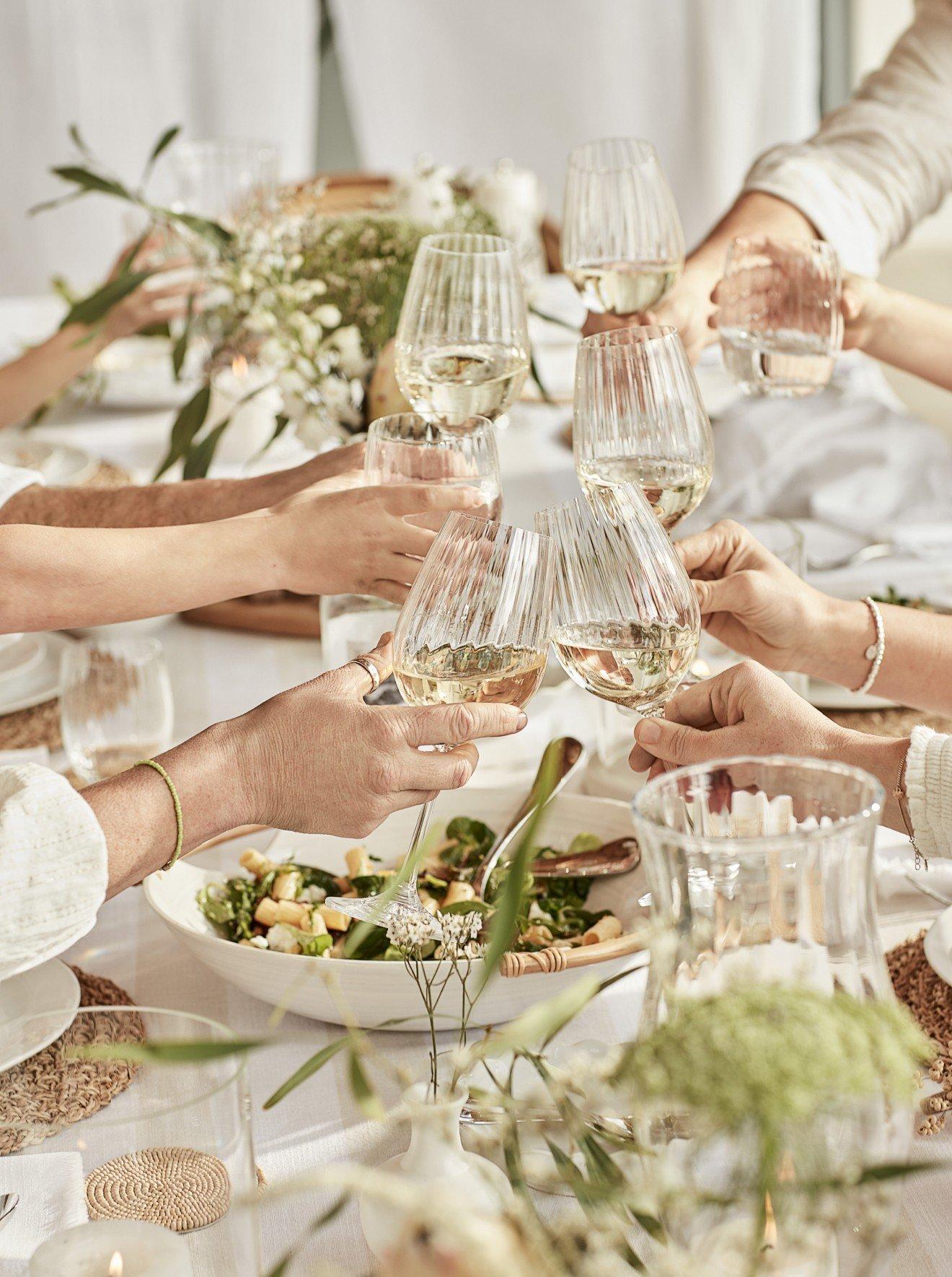 a group of people toasting glasses of wine at a dinner table