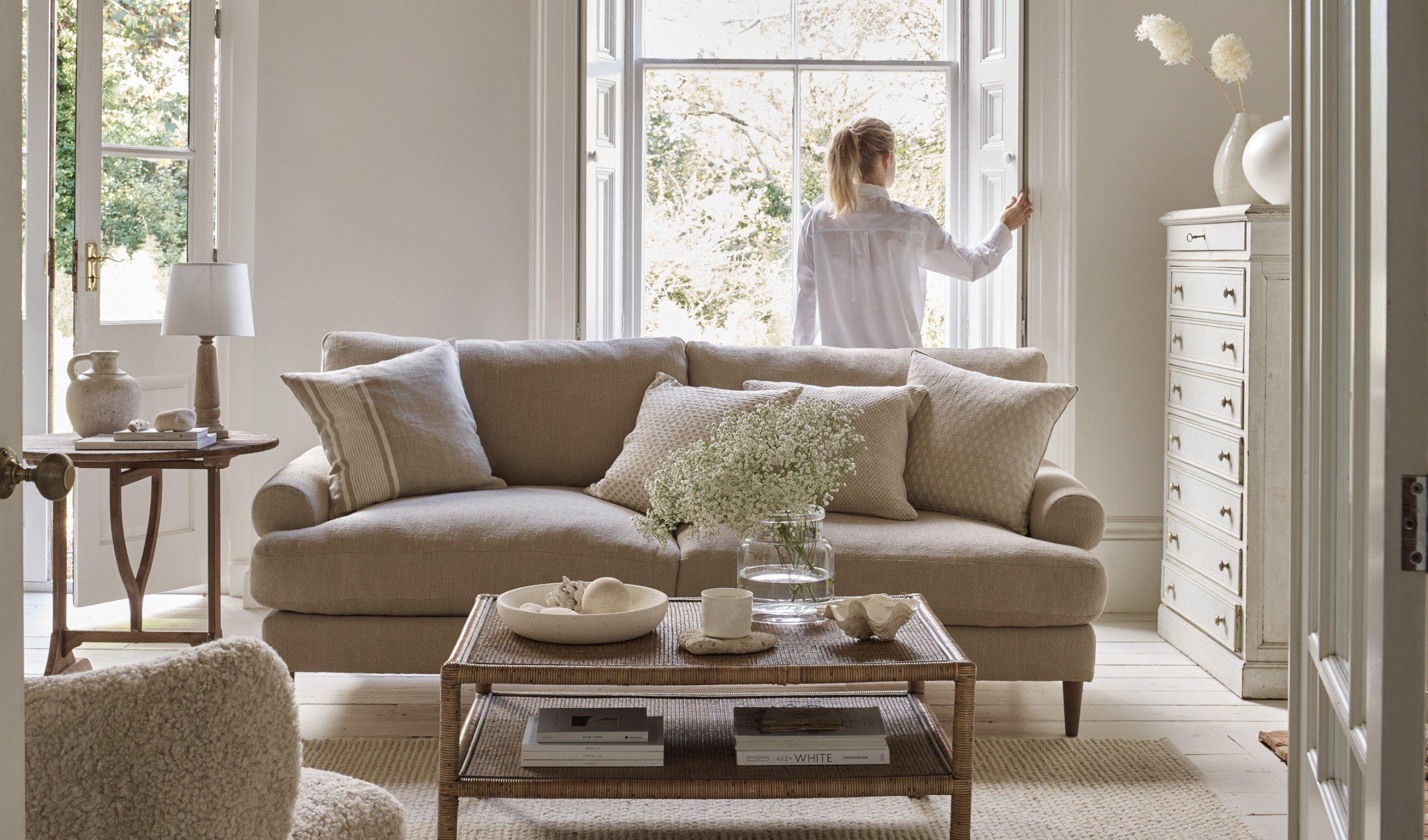 a woman standing in a living room looking out a window