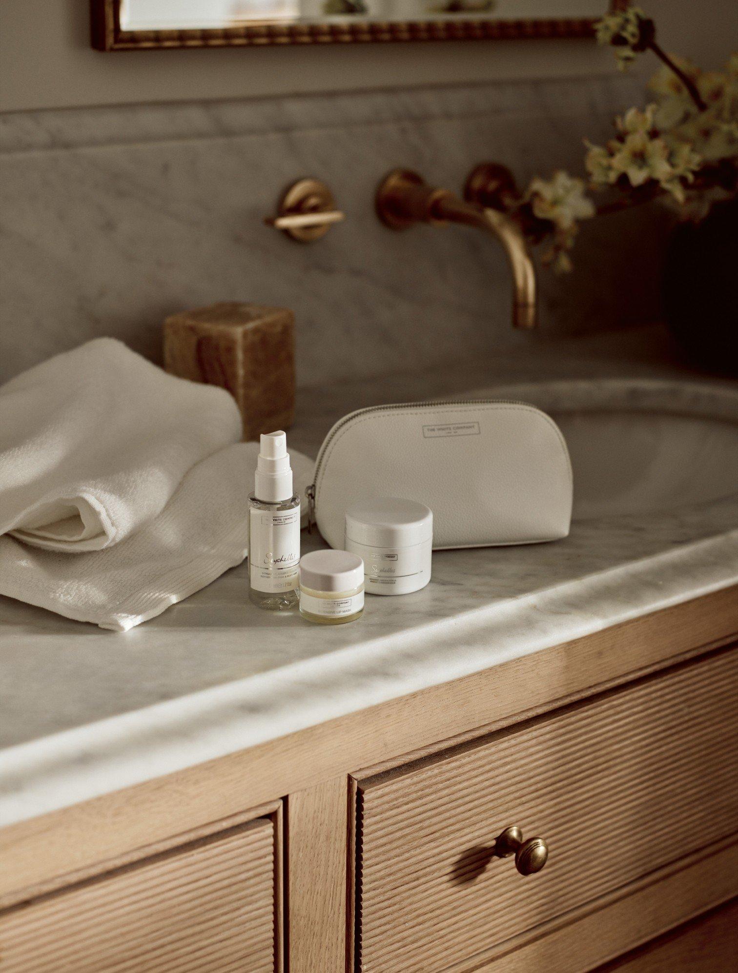 a bathroom counter with a sink and a bottle of lotion