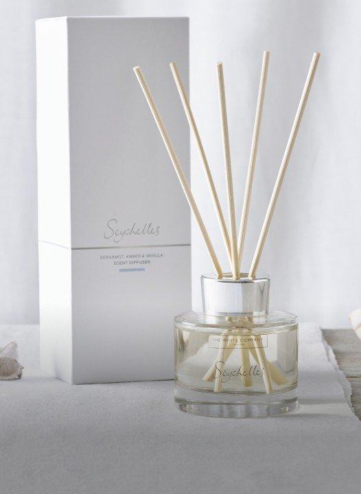 a reed diffuser with a white box next to it